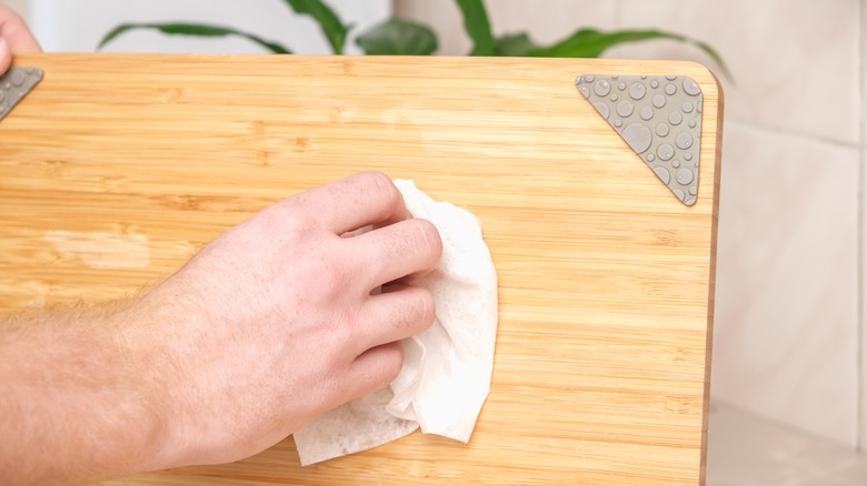 person cleaning cutting board