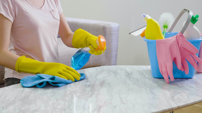 Spraying household cleaner on marble