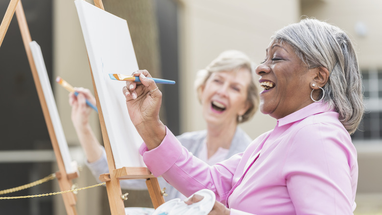 woman painting on canvas outside