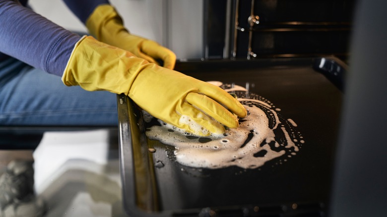 Person cleaning an oven