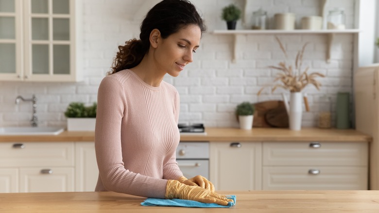 Woman wiping down countertops