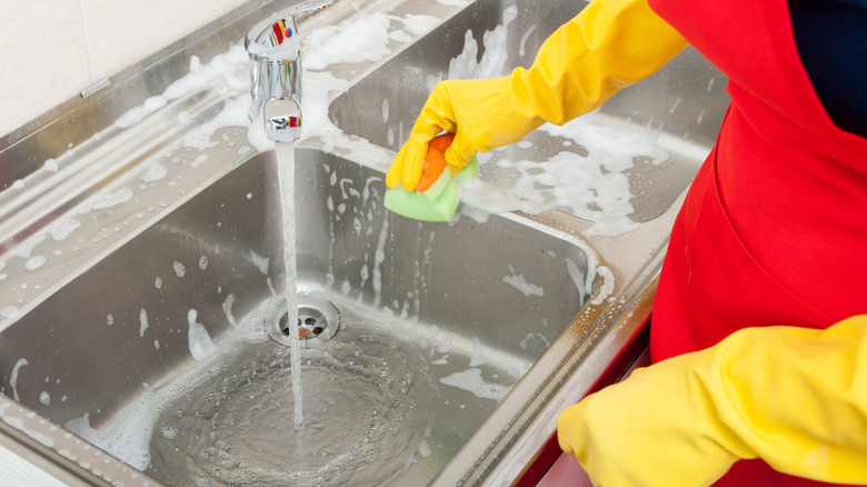 Person cleaning the kitchen sink