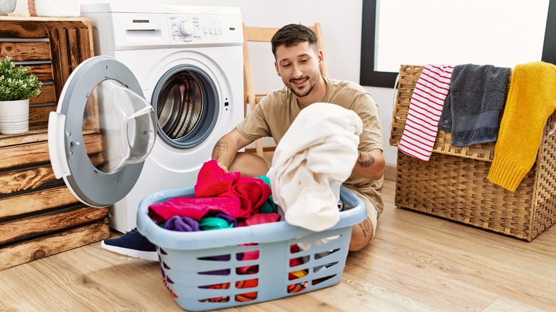 man doing laundry on floor