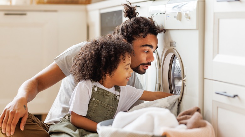 man checking laundry with daughter