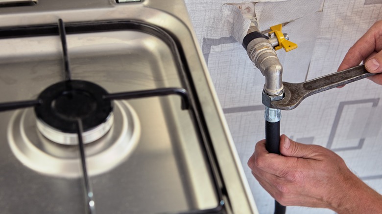 Person using spanner on gas pipe