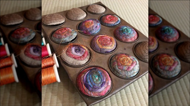 muffin tin with embroidered pieces