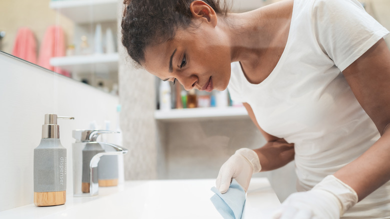 Woman wiping down sink