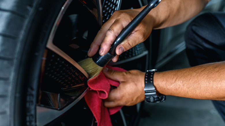 man brushing car wheel clean