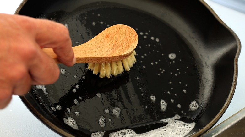 Close-up of cleaning cast iron skillet