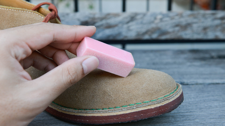 person using eraser on suede