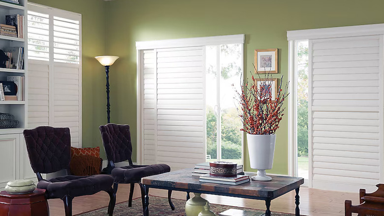 white plantation shutters over living room sliding door