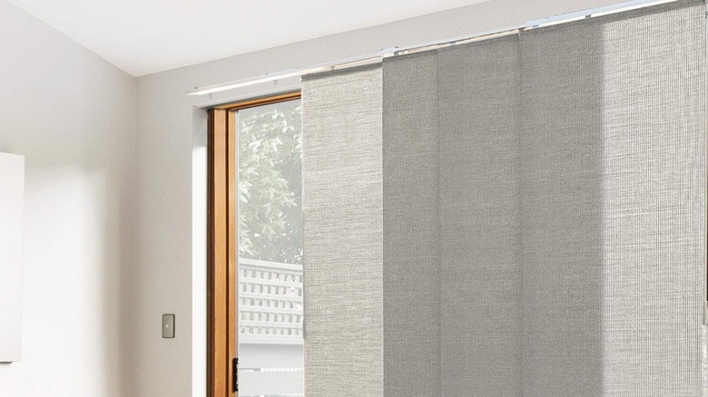 vertical panel blinds half-closed over sliding glass door