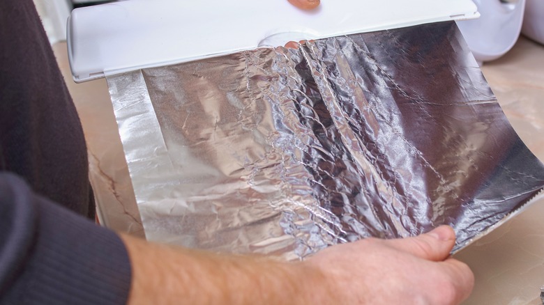 Person tearing out aluminum foil