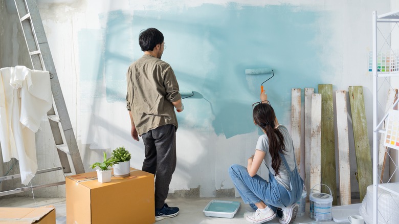 Couple painting wall