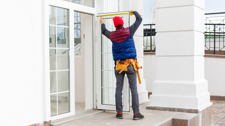 A person works to adjust a French door