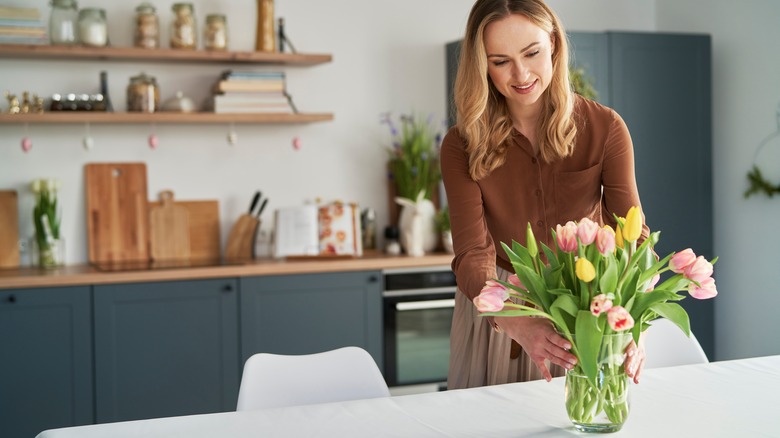 woman holding vase with tulips