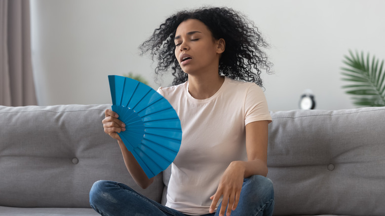 Person fanning themselves indoors