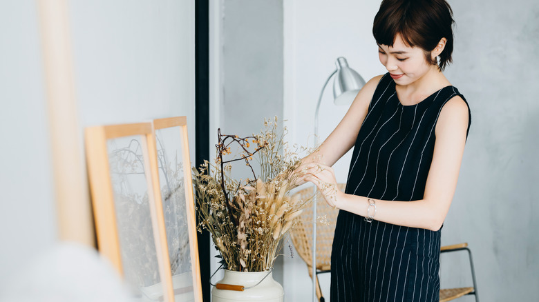 woman arranging dried flowers