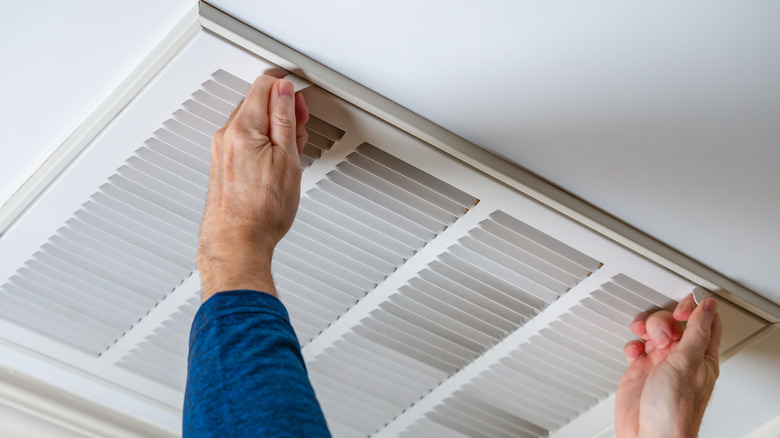 Person opening vent in home