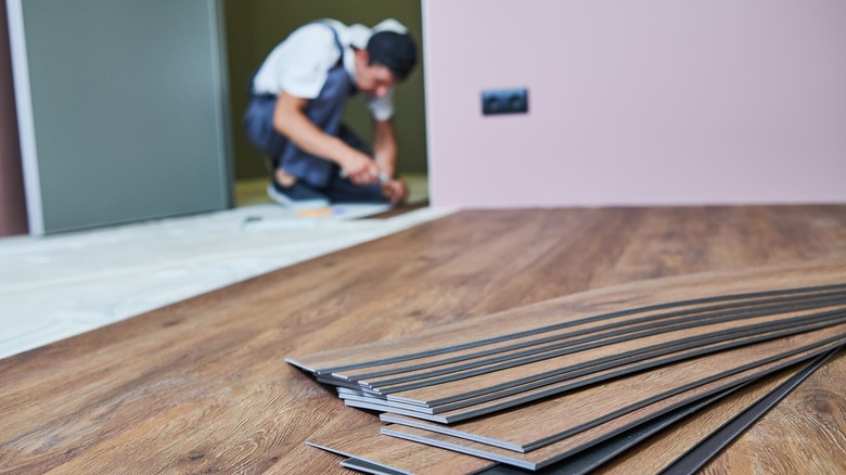 Worker laying vinyl flooring