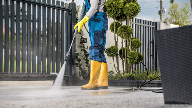 Person power washing driveway