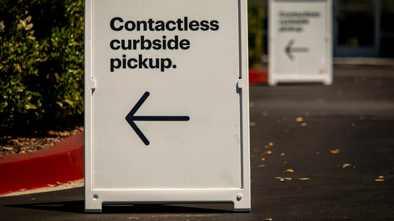 A sign for curbside pickup is outside a store