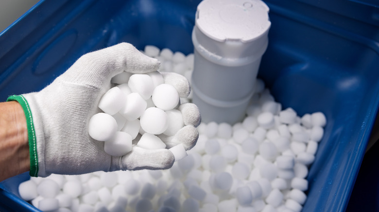 Person adding salt to a water softener