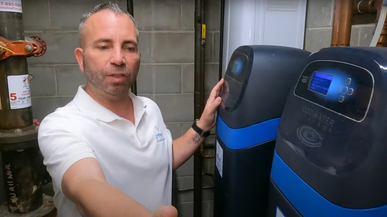 Man pointing at an installation of an EcoWater softener