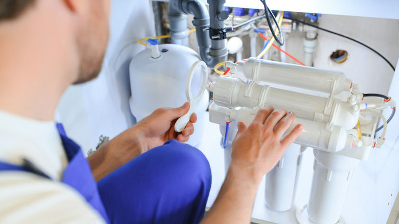 Man installs water filtration system