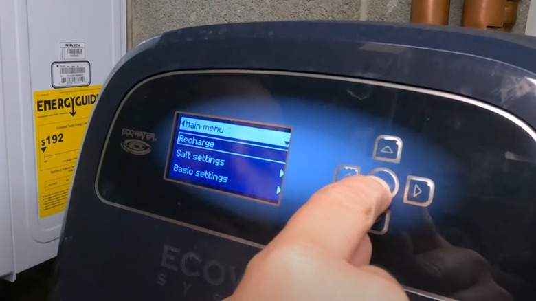 Person pressing a button on an EcoWater softener