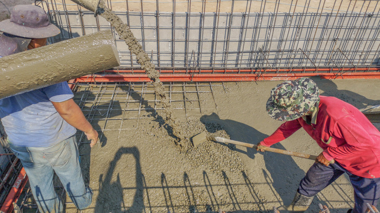 Workers laying concrete for pool