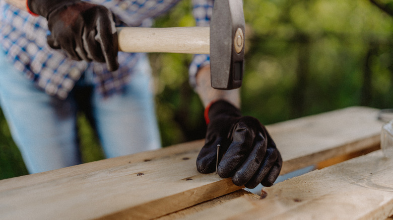 hammering nail in wood pallet
