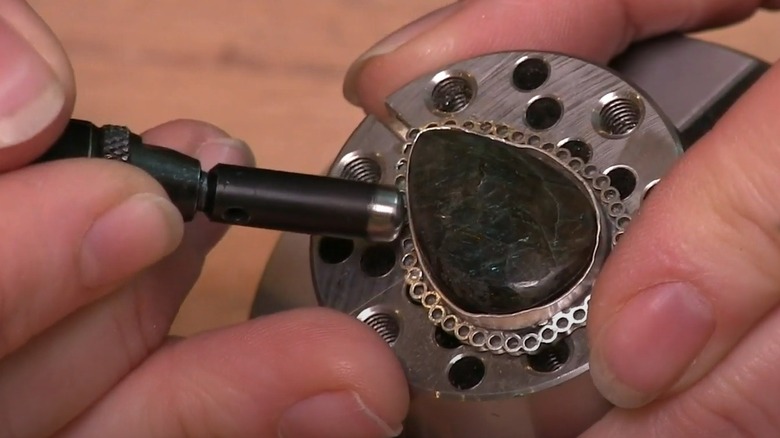 Person polishing metal with a rotary tool