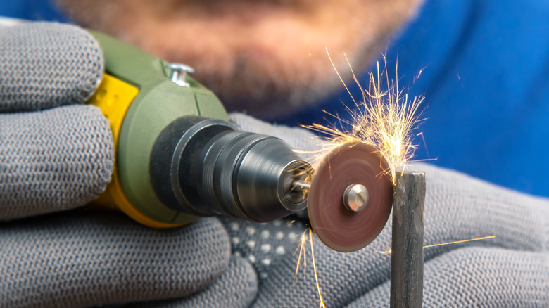 Person working on a piece of metal with a rotary tool