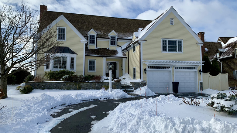 This house has snow in front an an almost clear driveway.