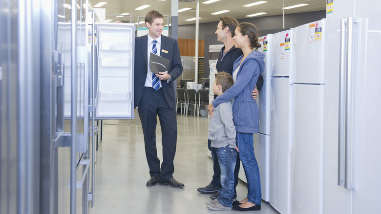 Family working with a salesperson to buy kitchen appliances