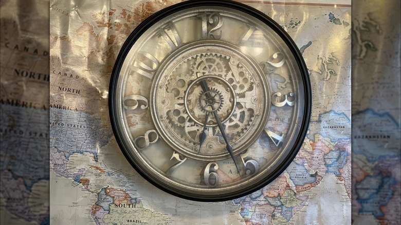 Large manual clock placed on a wall map