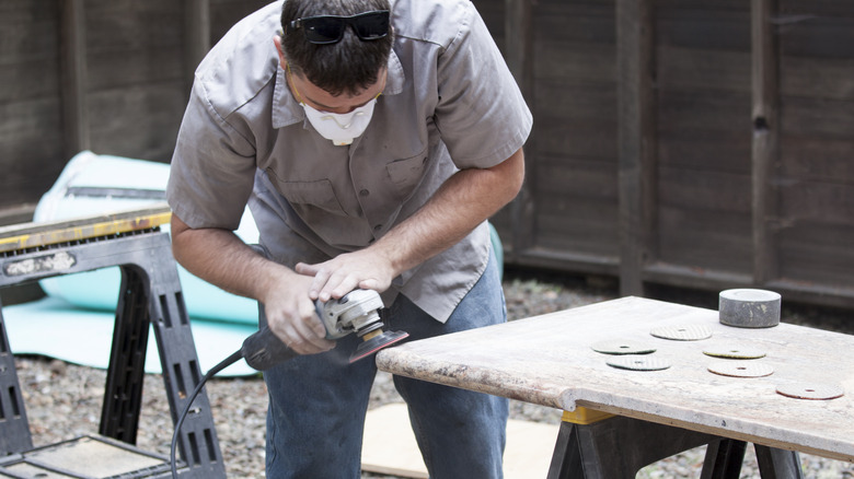 man buffing granite countertop