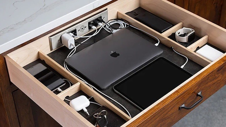 An open drawer with devices being charged inside