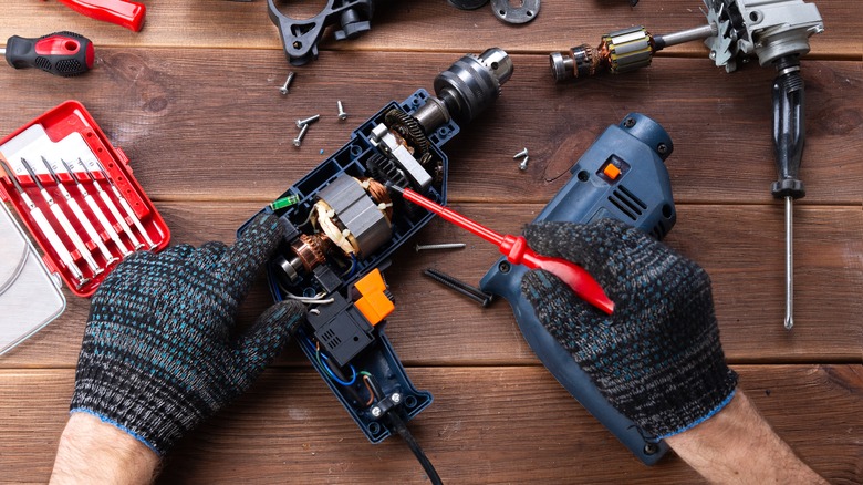 Person repairing a broken drill