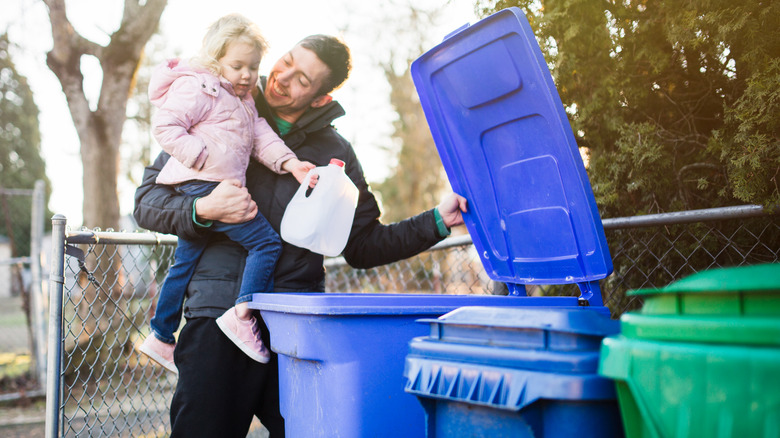 Dad daughter throwing jug into bin