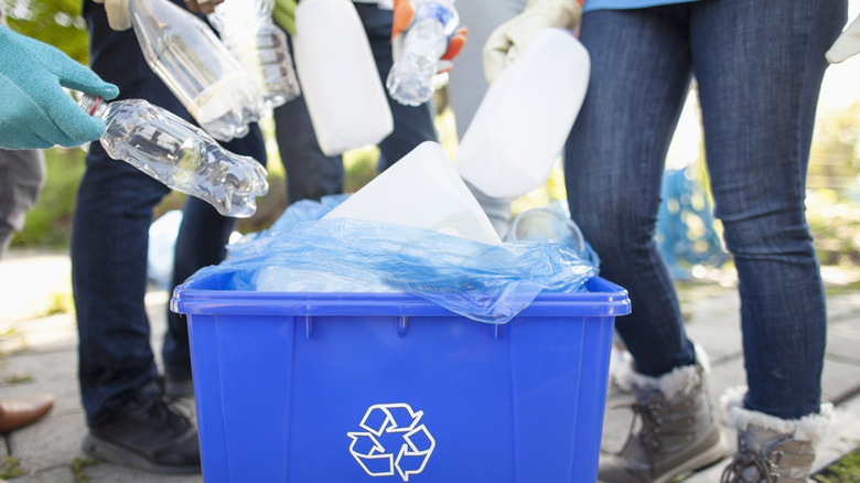 People adding items to recycling bin