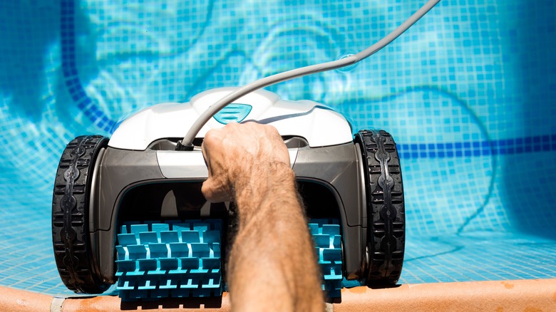 person using robotic pool cleaner