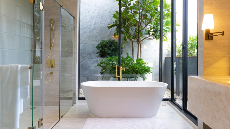 Freestanding white tub in a bathroom with a walk in shower