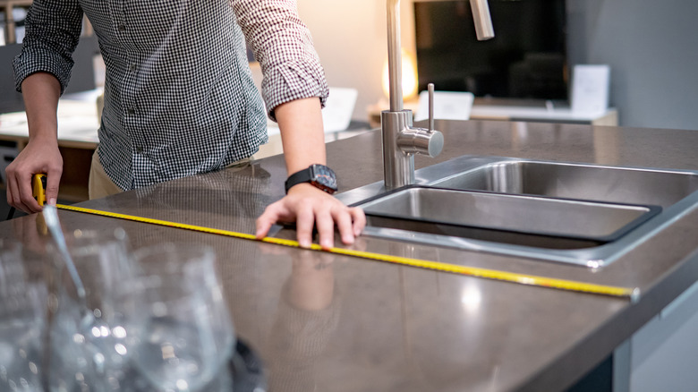 man measuring slate countertop