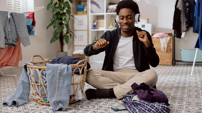 Man listening to music beside hamper