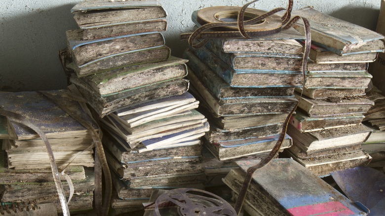 There is a pile of books covered in dirt and mold.