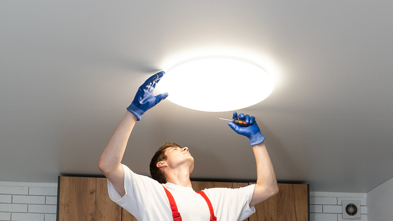 man installing ceiling light