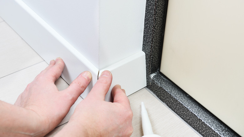 person installing mdf baseboard