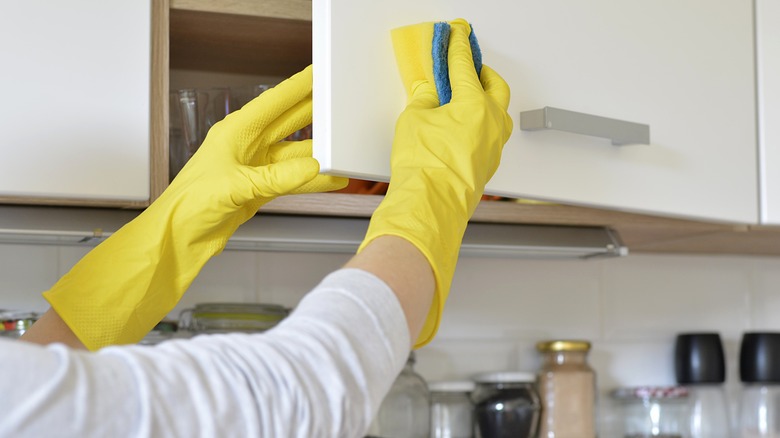 Cleaning kitchen cabinet using scrubber